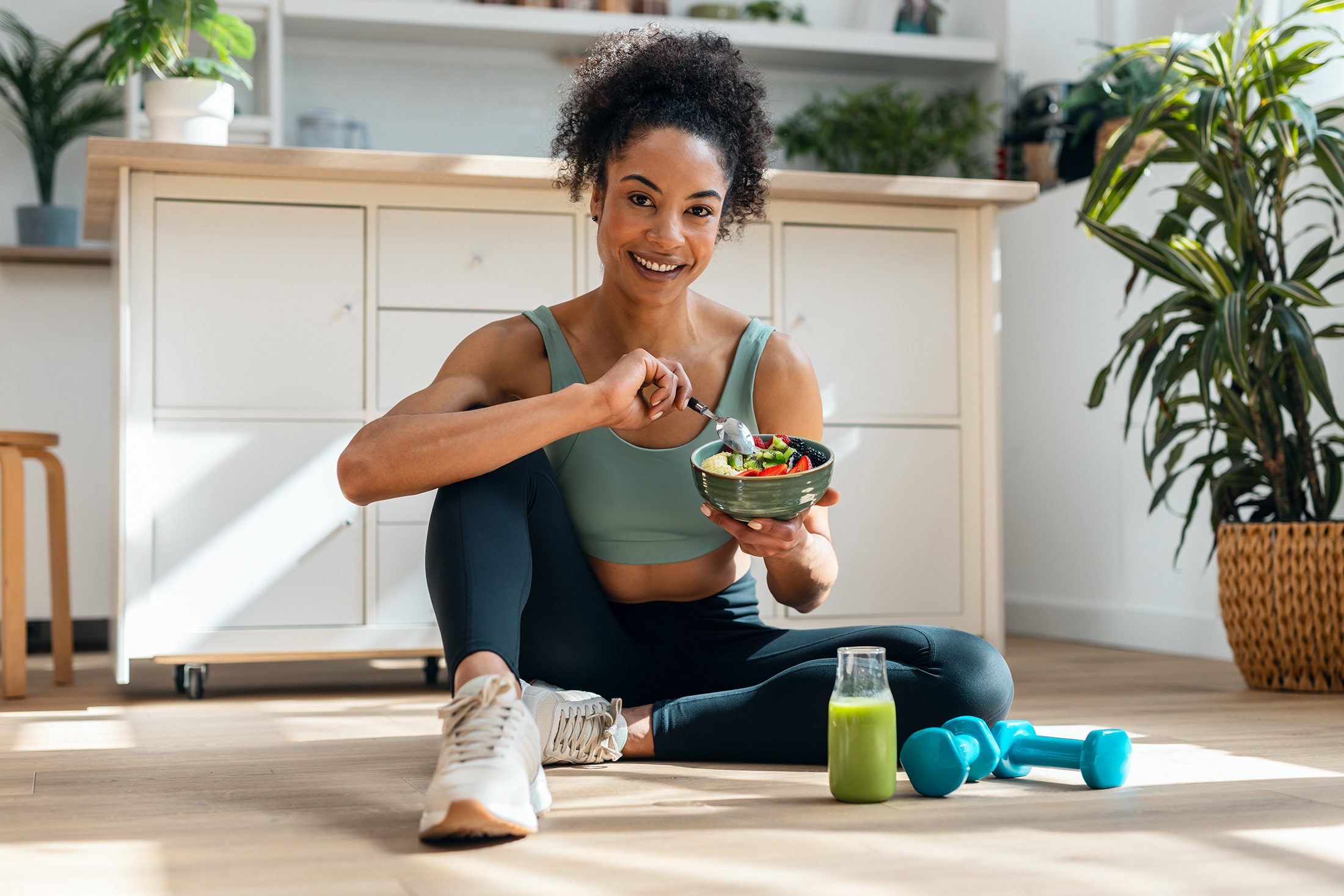 woman in workout clothes eating a salad