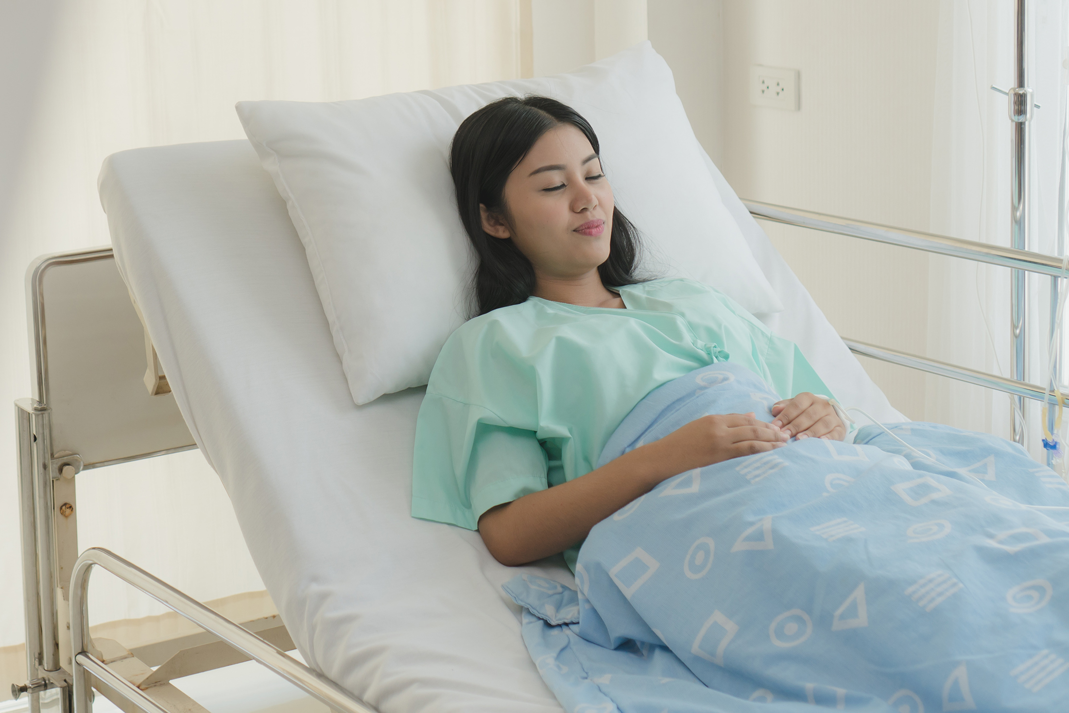 woman on bed resting after tummy tuck