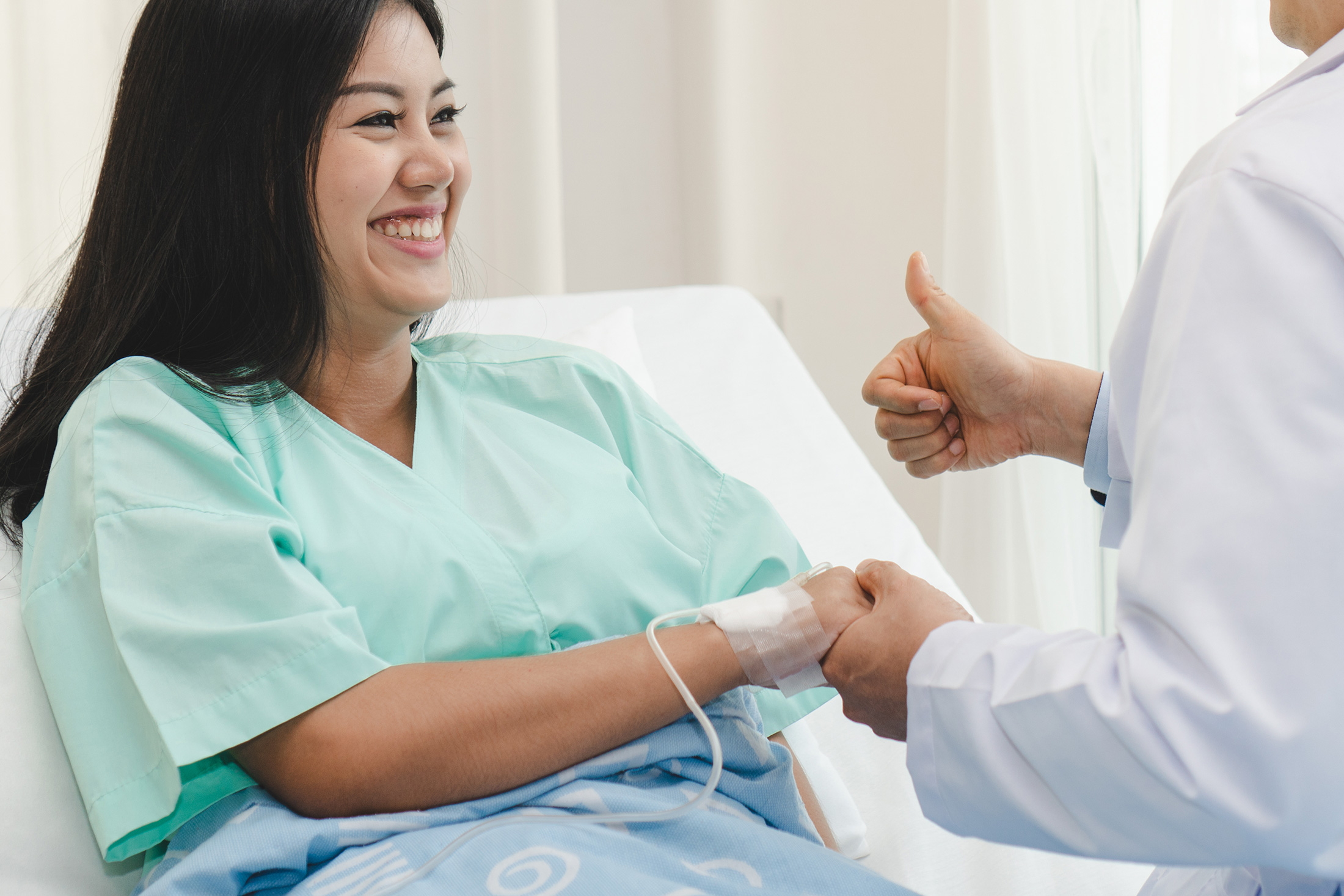 woman on bed talking to surgeon